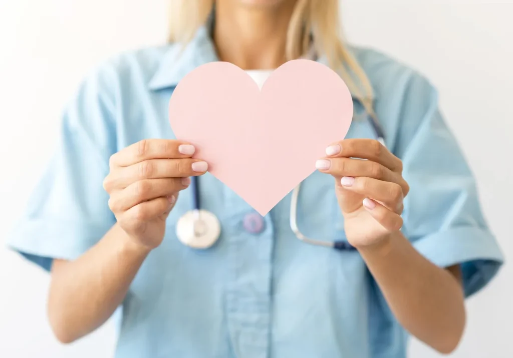 front-view-female-doctor-with-stethoscope-holding-paper-heart-scaled